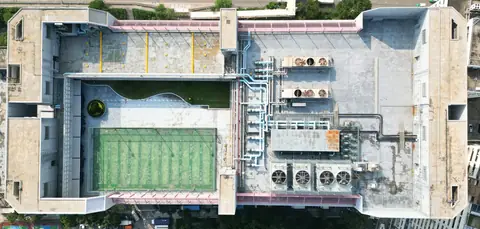屯門吉田大廈屋頂垂直航拍，可見綠色球場、多組機電設備及管道