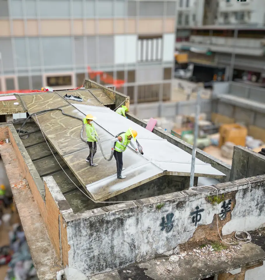 粉嶺聯和市場三名工人以噴塗設備為斜面屋頂鋪上白色表面層