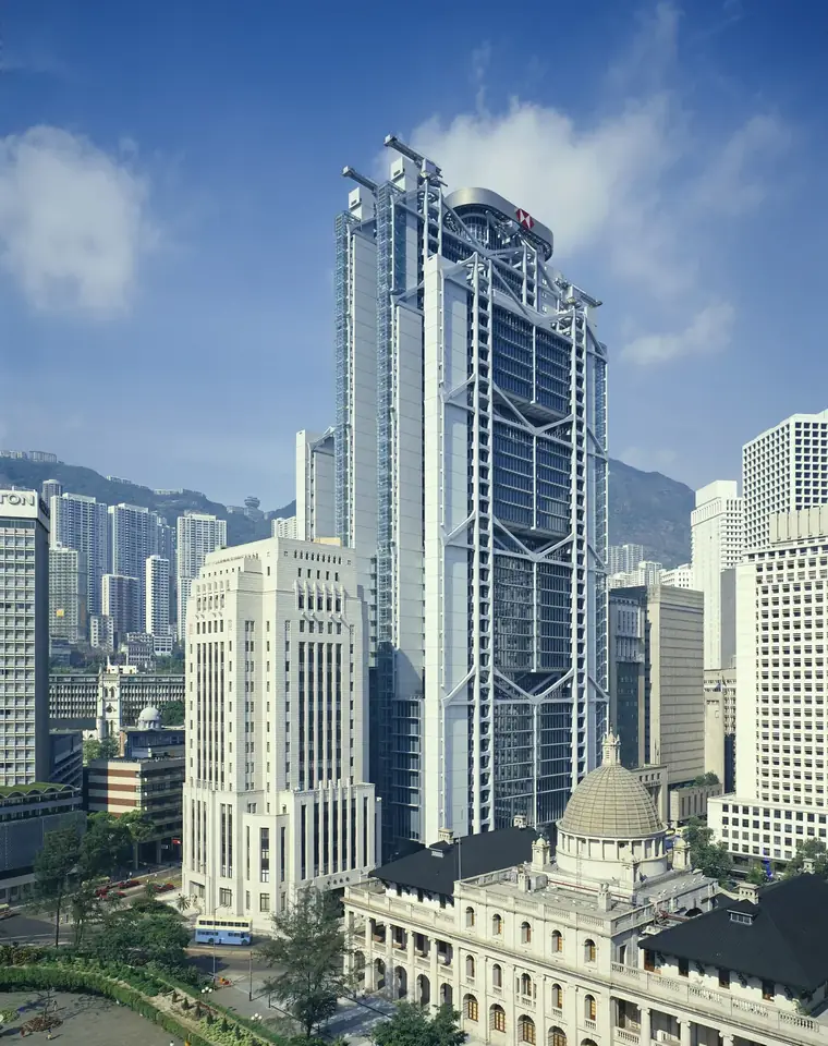 香港中環匯豐總行大廈外觀，周圍可見市區樓宇與山景