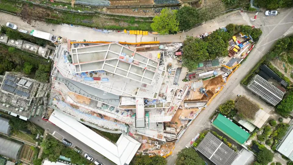 嘉道理農場保育中心工地航拍俯視，可見建築布局、周邊道路及綠化環境