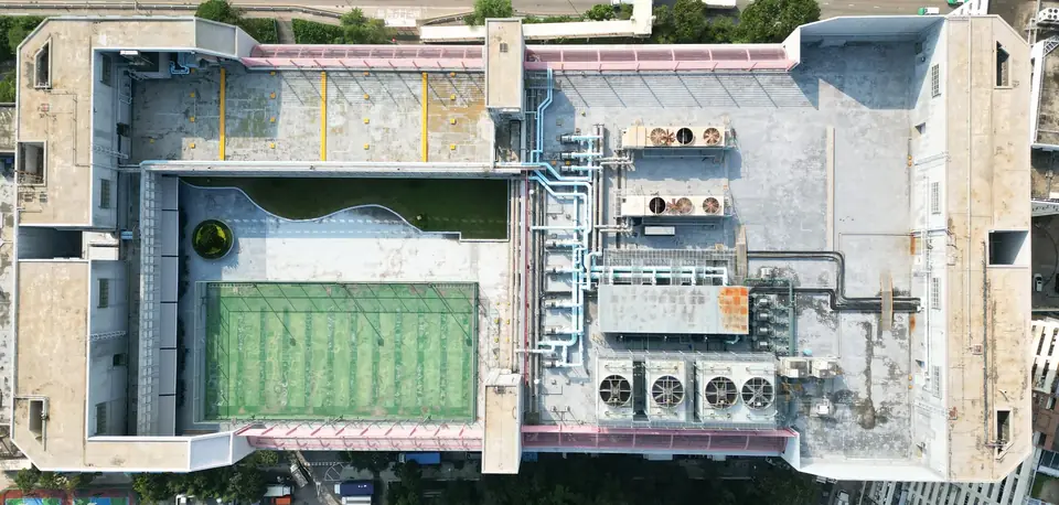 屯門吉田大廈屋頂垂直航拍，可見綠色球場、多組機電設備及管道