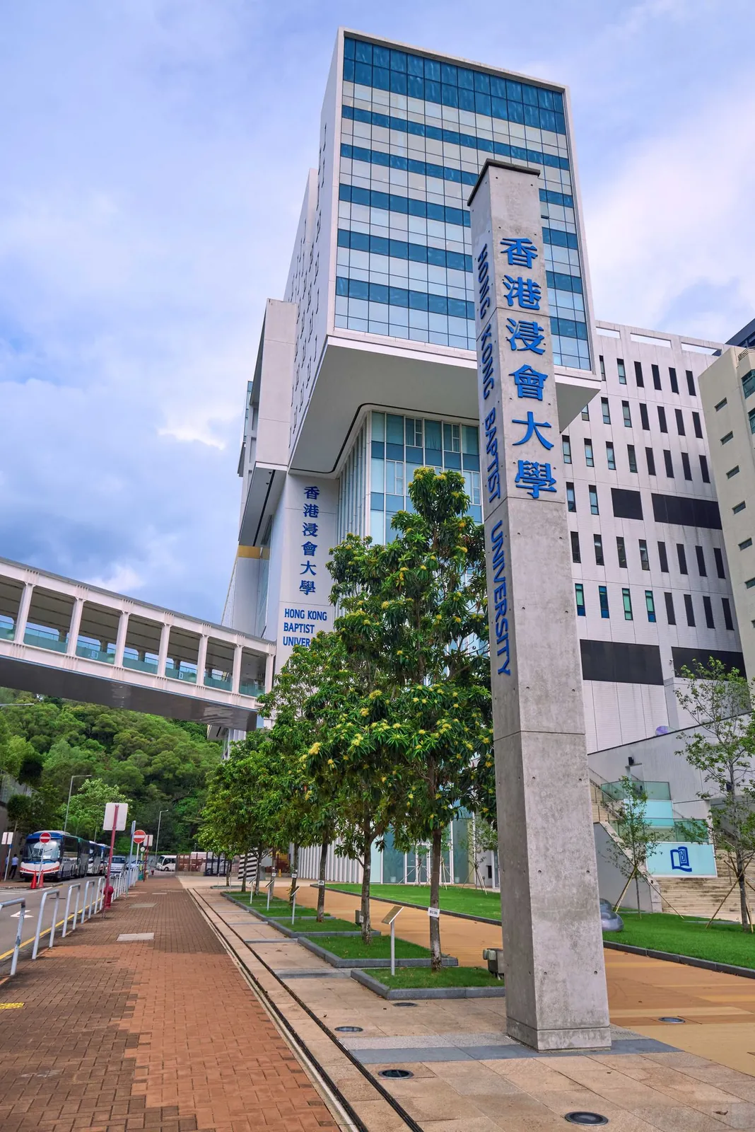 Campus entrance sign and tall academic building at Hong Kong Baptist University in Kowloon Tong.