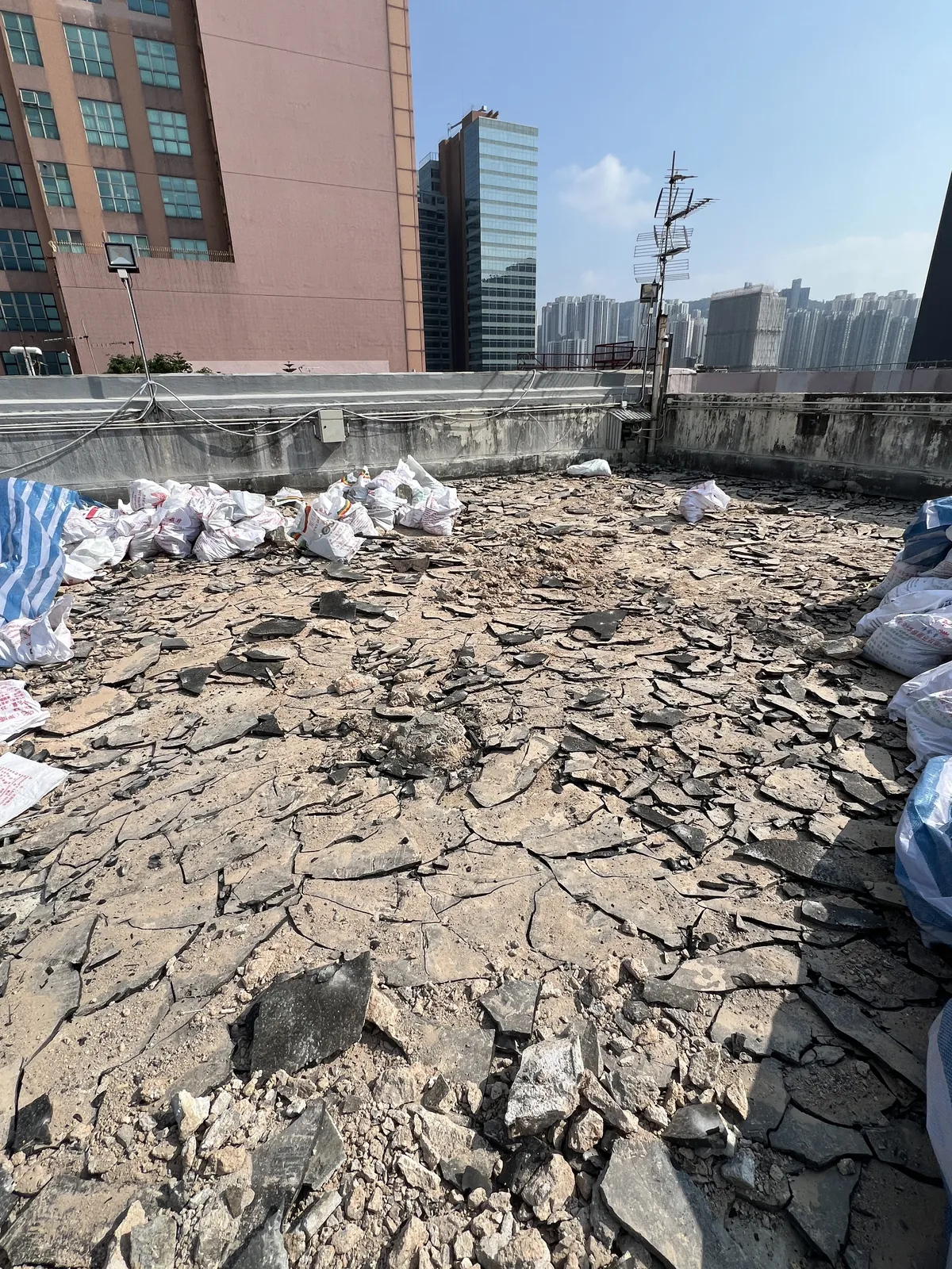 觀塘鴻運工業大廈工程：已拆除舊面層並堆有碎料的天台