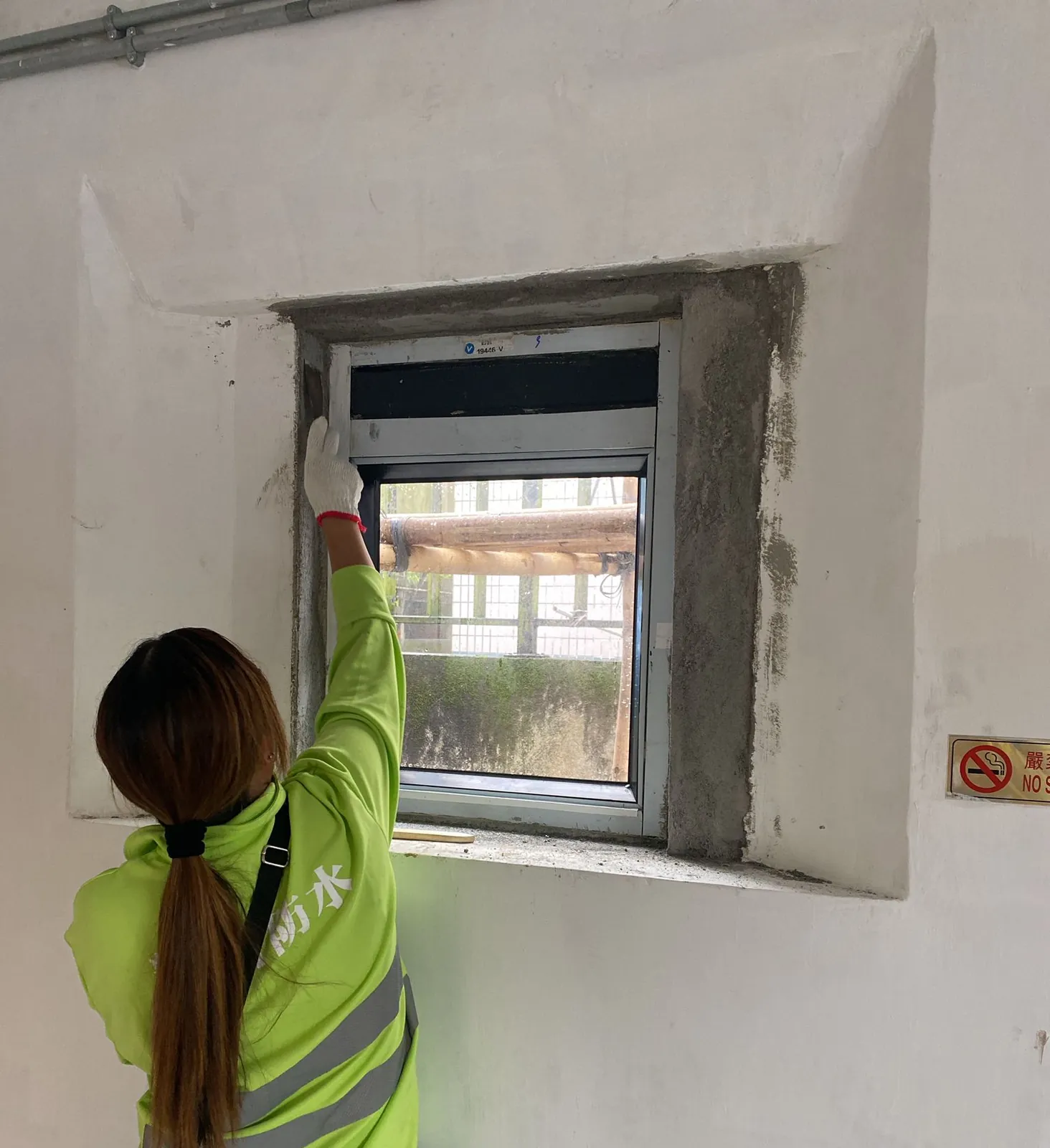 Worker carrying out wall treatment around an interior window opening at Law Uk Historic House