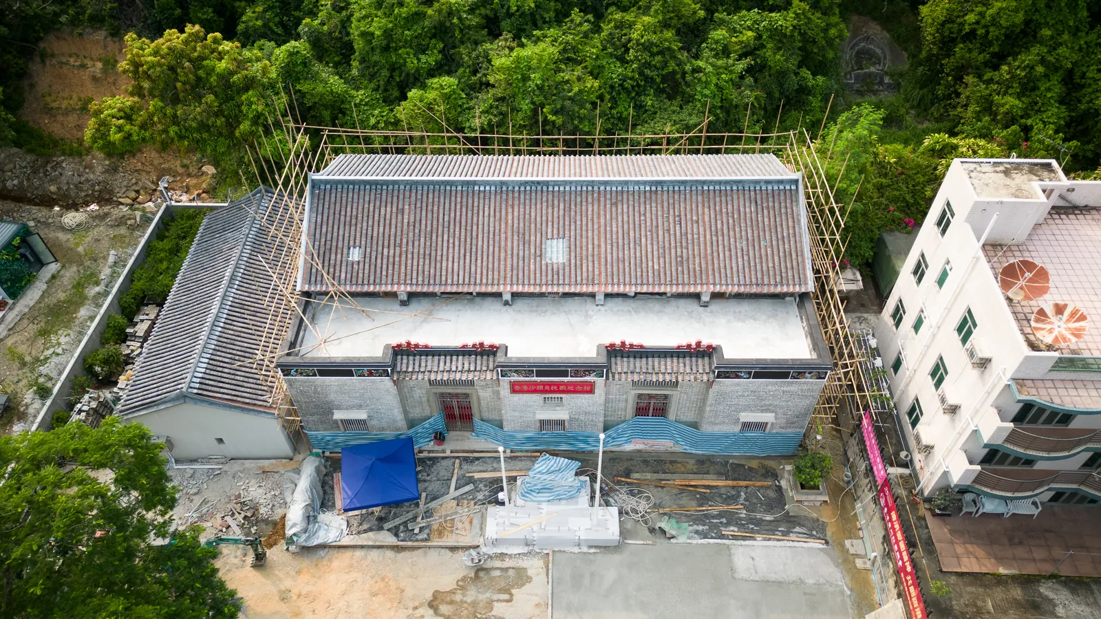 Aerial front view of Law Uk Historic House, its courtyard and surrounding scaffolding