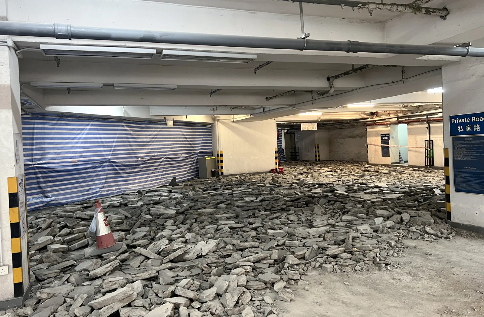 炮台山理文商業中心停車場地面鋪滿破碎混凝土塊，旁邊有雪糕筒與圍封布