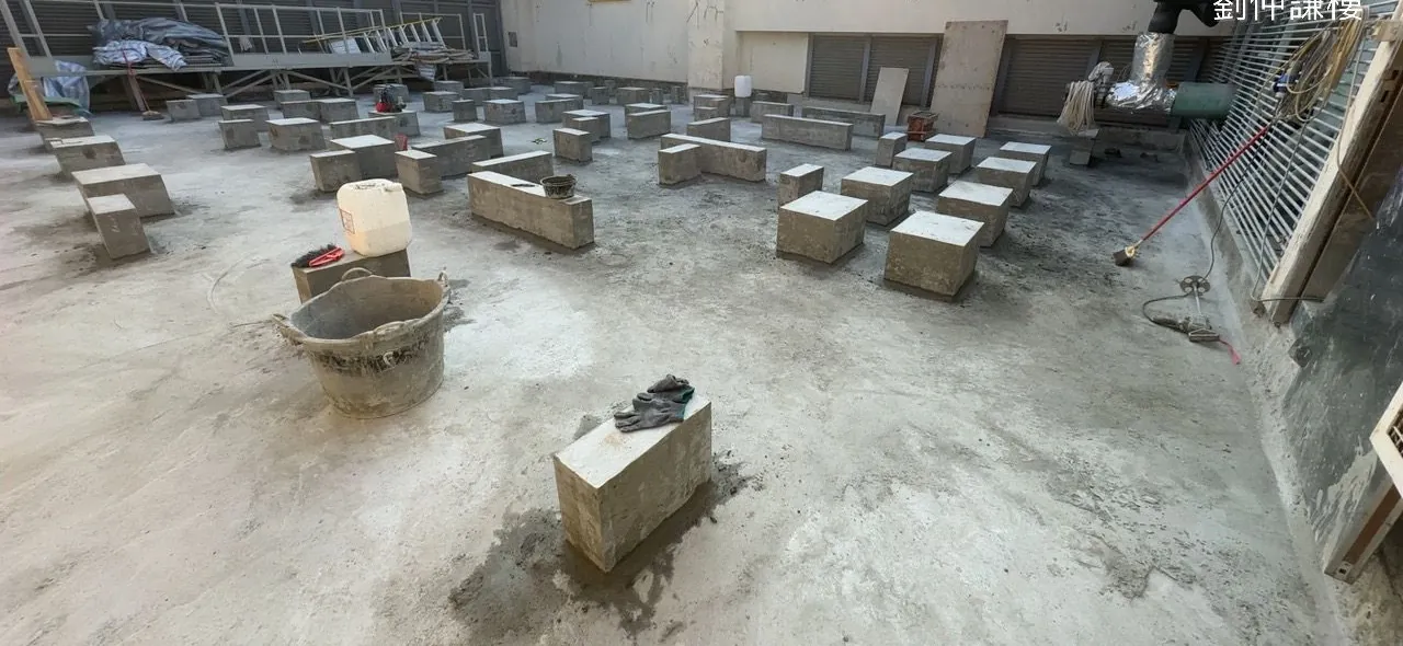 屯門嶺南大學屋面排列多個矩形基座,地上放有桶及工具