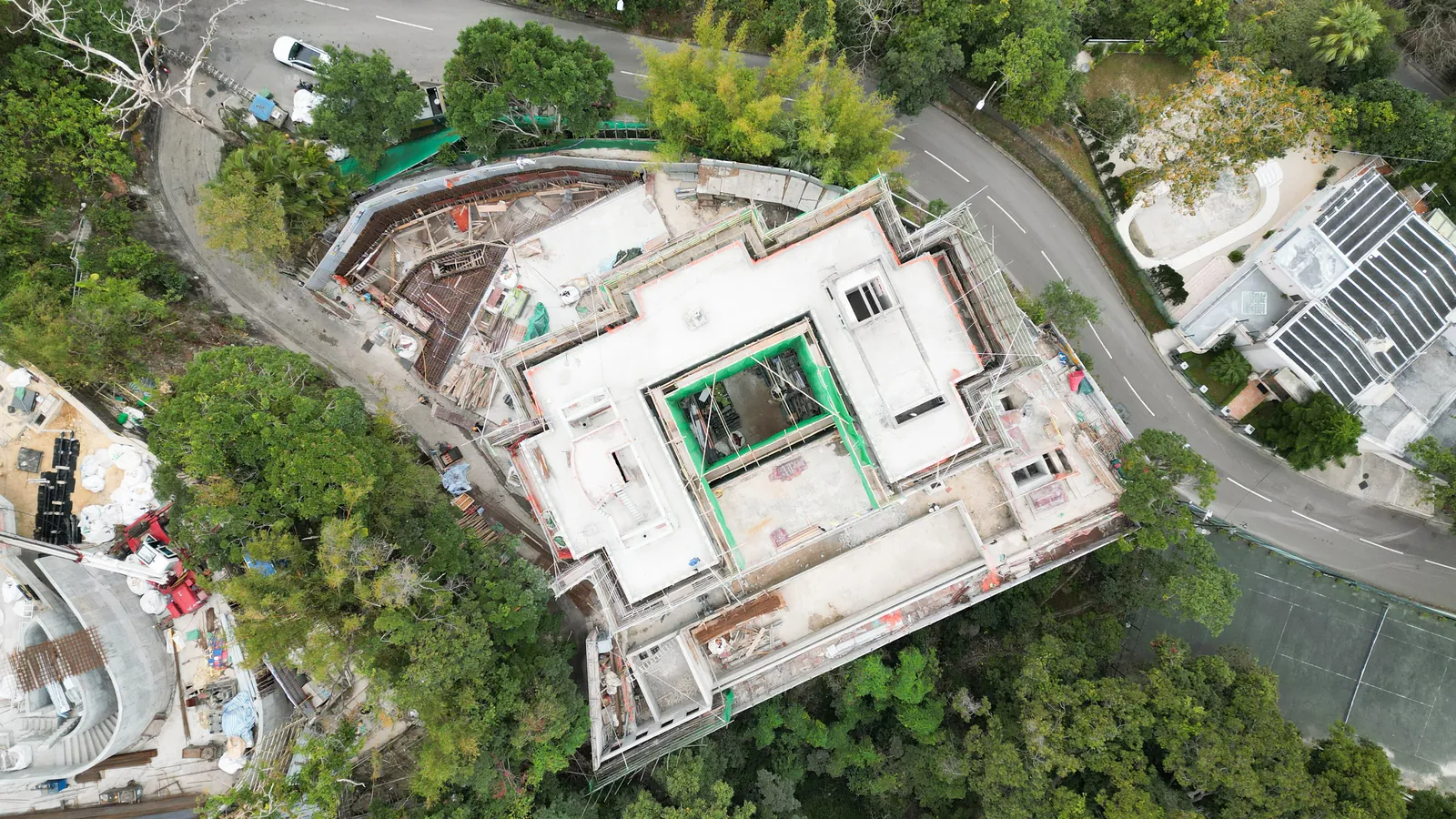 Top-down view of the roof, curved road and surrounding trees at No. 3 Middle Gap Road, The Peak