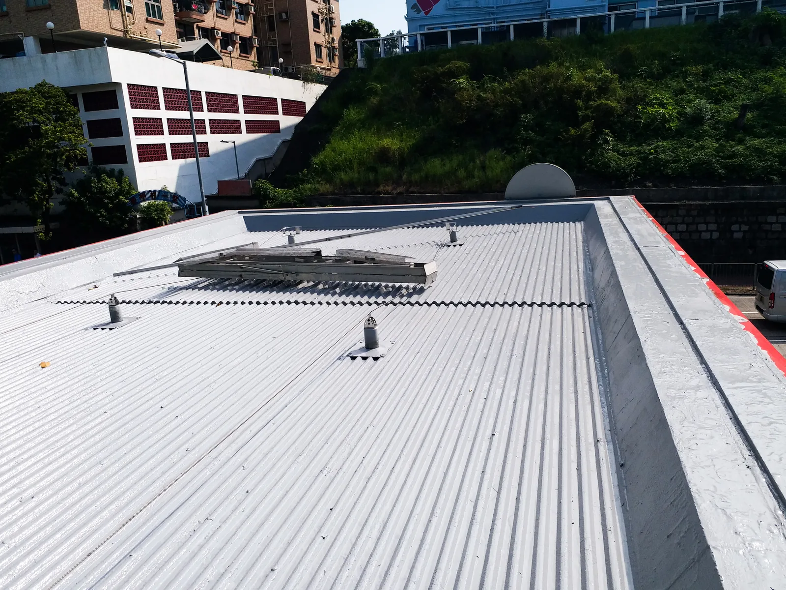 香港加油站白色波紋頂棚、屋面設備及後方綠化山坡