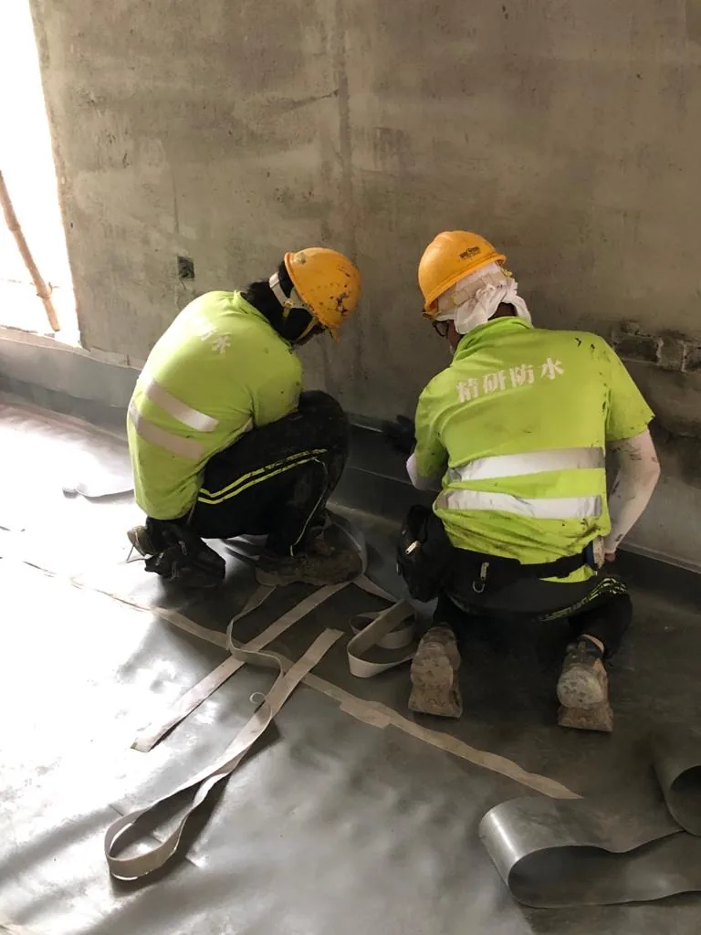 薄扶林道86A至86D工程：兩名工人在樓內牆地交界鋪設灰色卷材