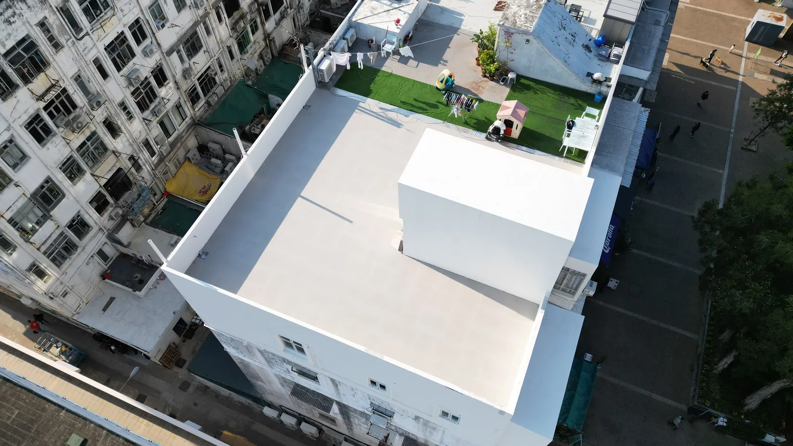 高空俯瞰西貢灣景街白色平屋面和中央天台構築物,旁邊設有人造草地