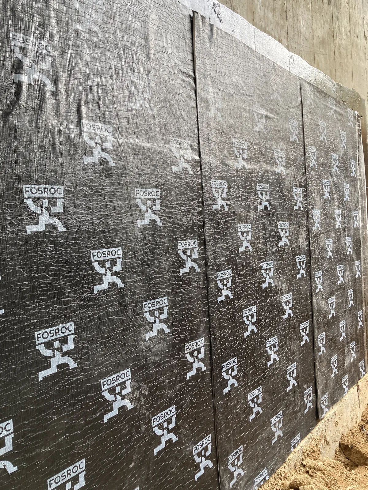 Close-up of black panels meeting a concrete corner at the Villa Panova site in Sai Kung.