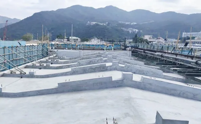 沙田馬場馬廄屋面排列多道淺灰色凸起分隔牆，旁邊設有大型管道