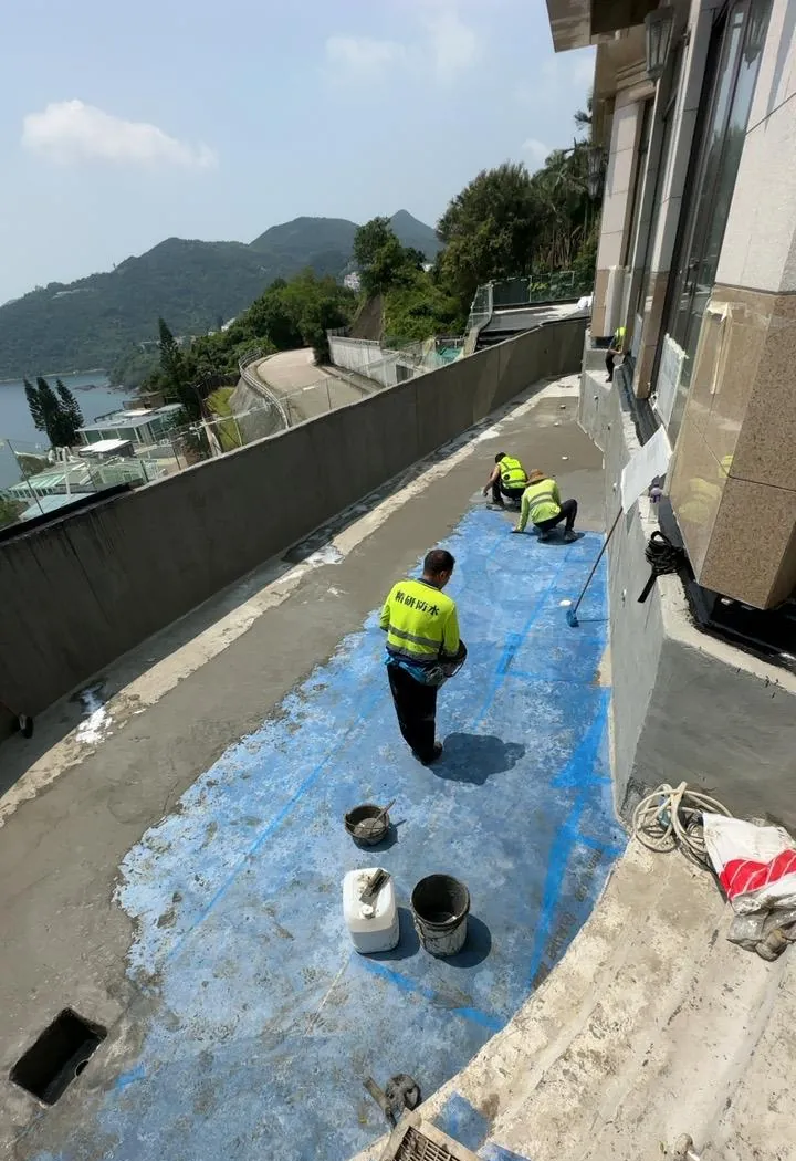 銀線灣銀臺路工程:兩名工人在已鋪藍色底層的露台面施工
