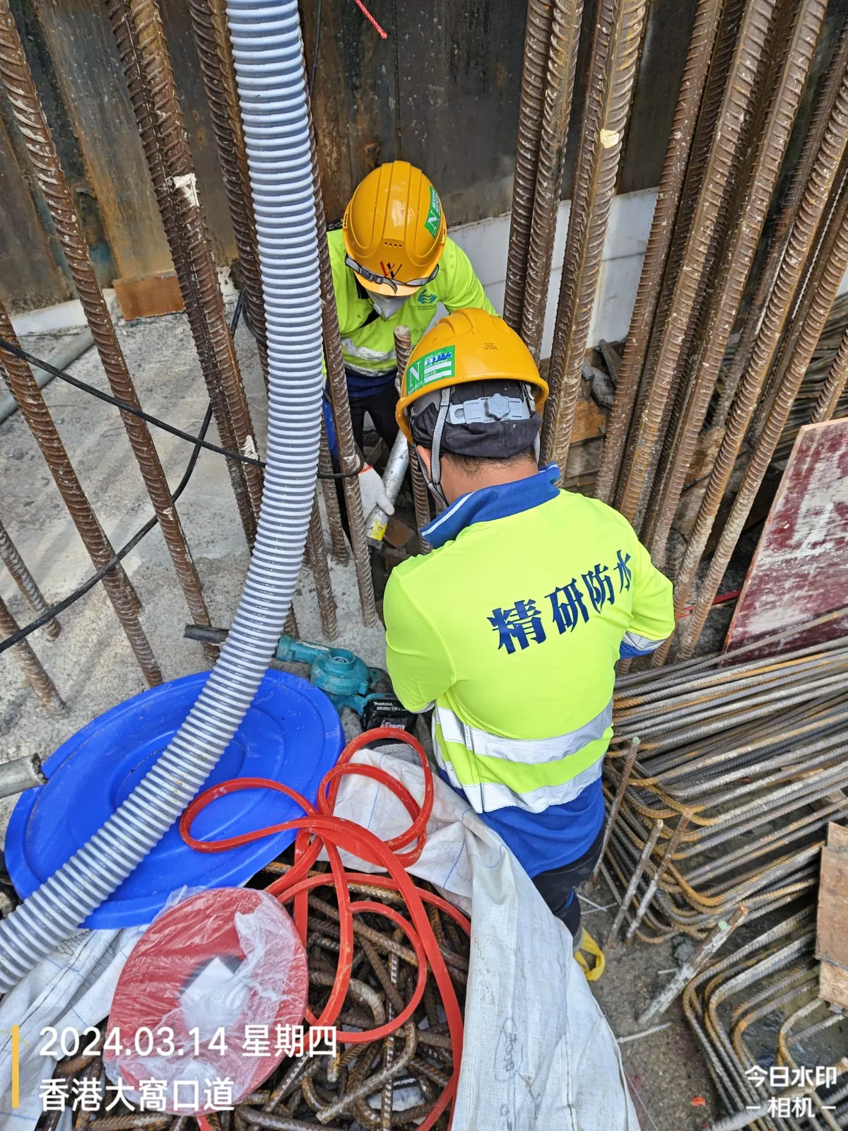 大窩口道公營房屋工程:工人在密集鋼筋之間處理管道及施工設備