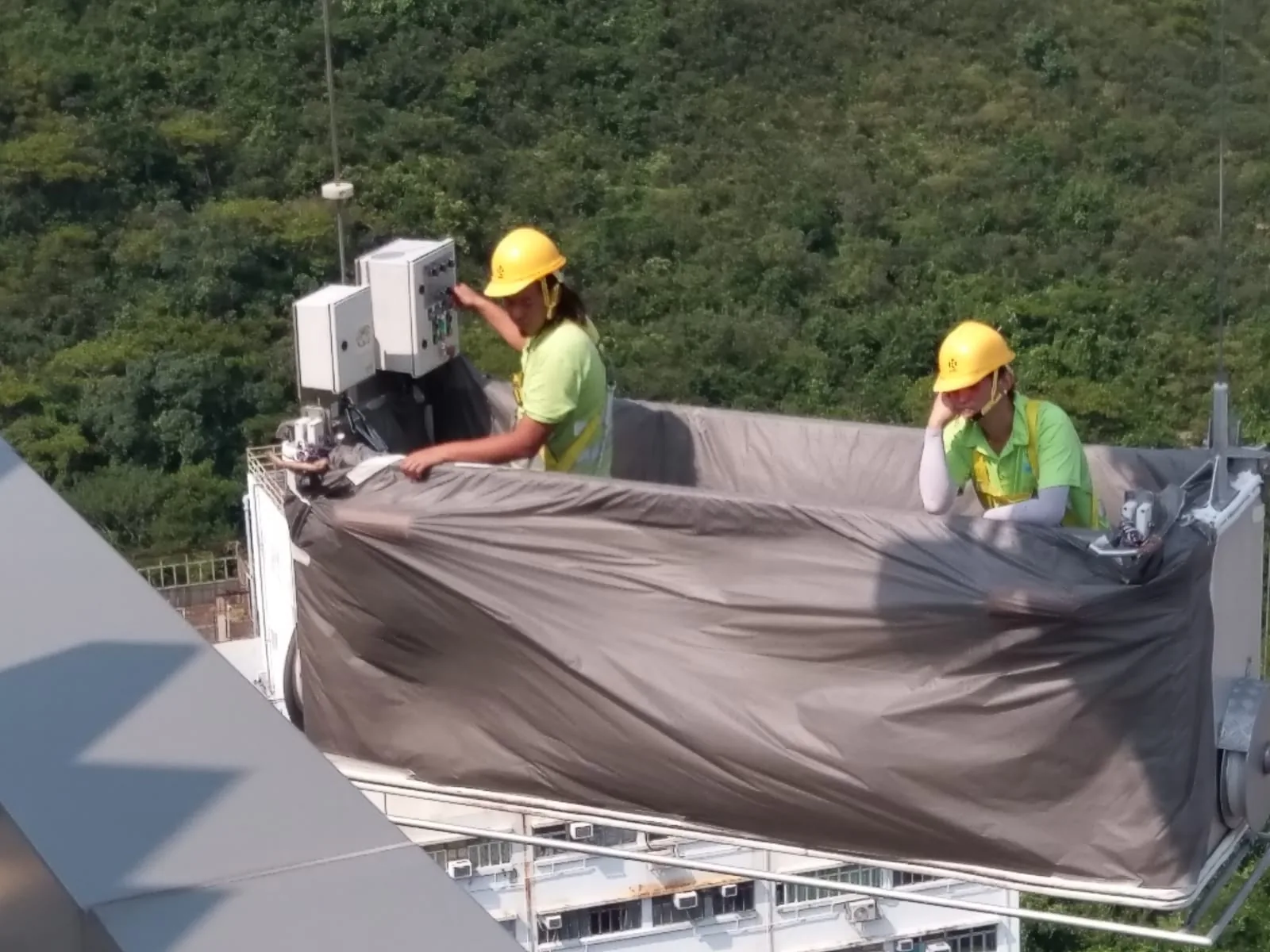 黃竹坑嘉尚匯兩名工人在懸吊平台上操作控制箱並查看外牆邊位