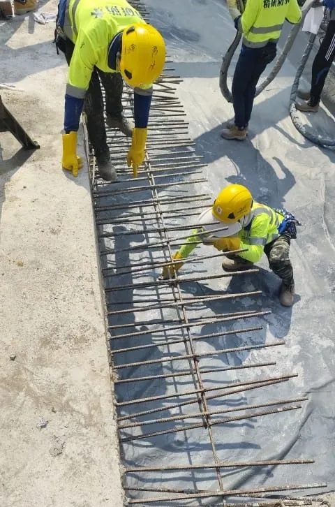 Workers carrying out construction around a reinforced floor opening at the Wang Chau public housing site